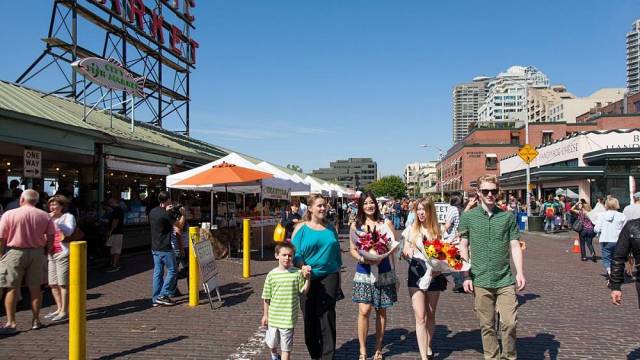 Family walks with flowers and other finds from Pike Place Market near Seattle waterfront