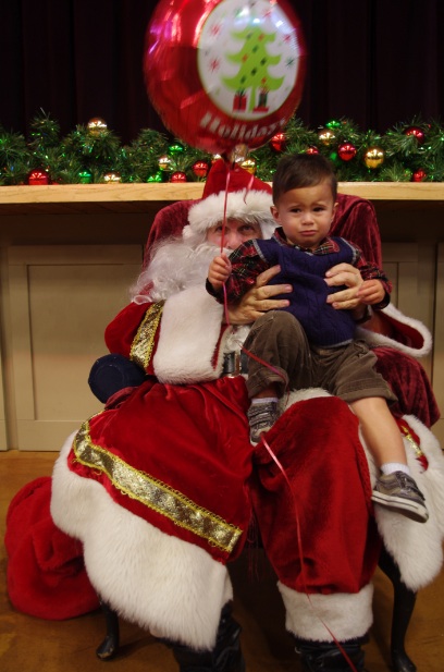 Even a big red holiday balloon can't stop Thomas' tears as he sits on Santa's lap. 