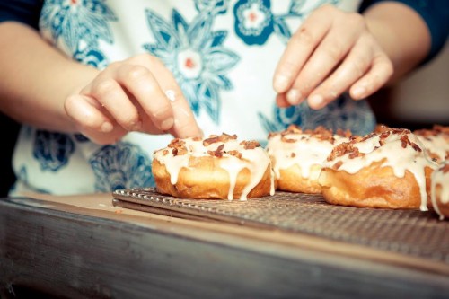 A pair of hands prepares to eat a Dynamo donut