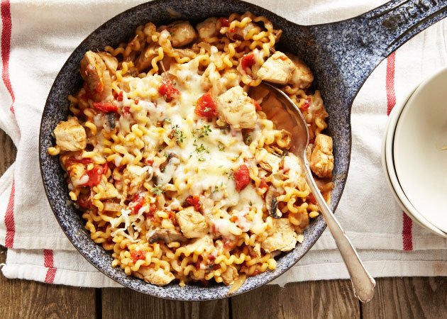 An iron skillet filled with One Pot Tomato Chicken Pasta