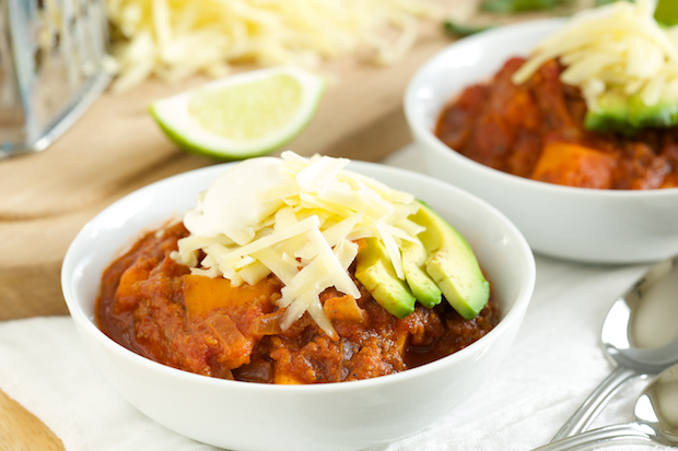 Two bowls of Sweet Potato Chili are topped with avocado