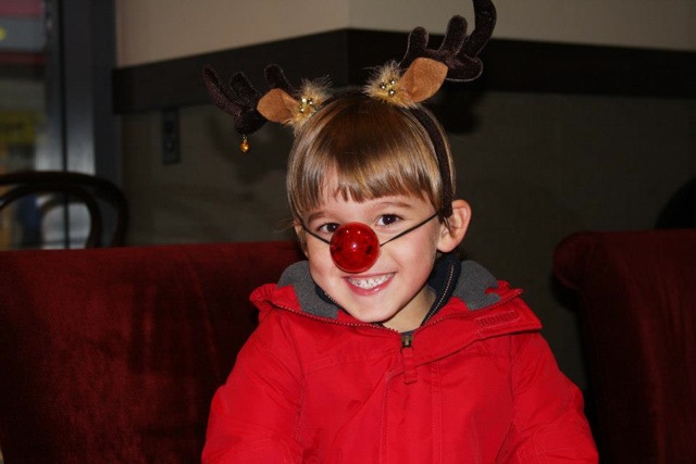 Little kid with rudolph antlers and nose