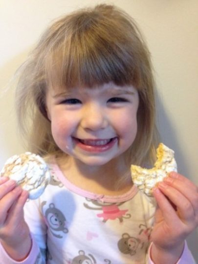 A cute little girl smiles after biting into lemon cookies