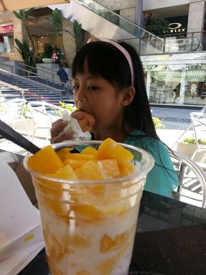 Girl enjoying cream puff at Beard Papa by Precy B via Yelp