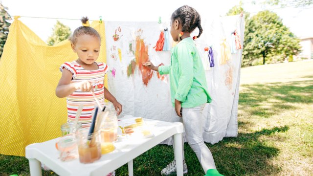picture of little girls painting on canvases, one of the best outdoor paint party ideas