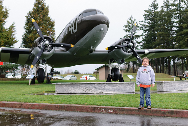 boy standing in front of airplane