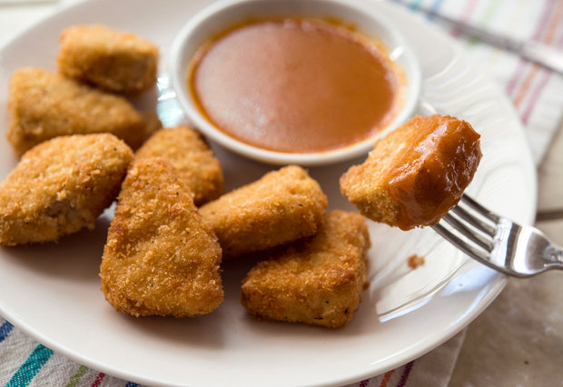 Vegetarian, plant-based chicken nuggets from Veestro meal delivery service sit on a plate next to dipping sauce.