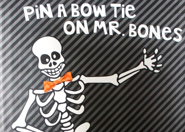 A print of a skeleton wearing a bow tie invites you to play a Halloween party game