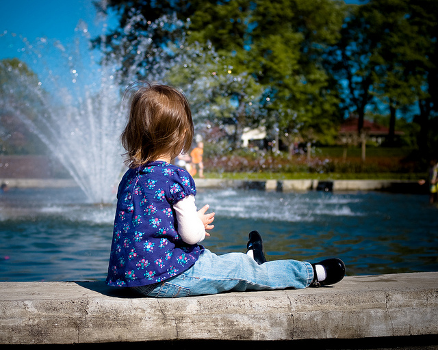 Child sitting near fountain