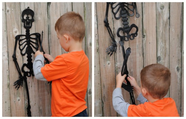 a boy in an orange shirt reassembles pieces of a plastic skeleton during a Halloween party game