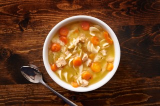 a white bowl holds homemade chicken noodle soup