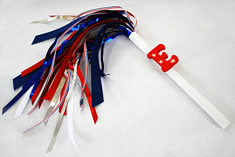 A plastic handle with red, white and blue metallic material gathered at the end to look like a sparkler as a fourth of July craft