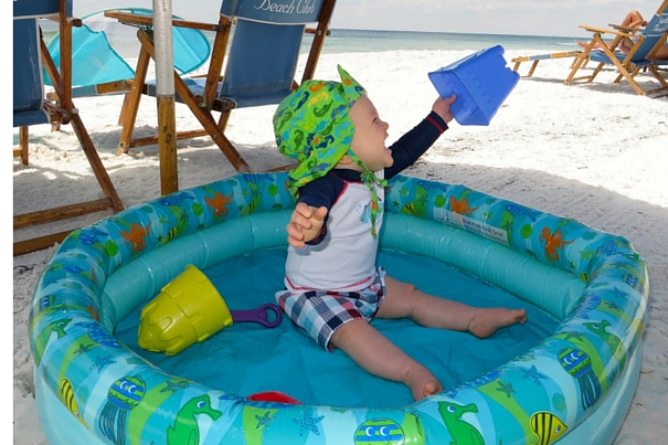 toddler in a kiddie pool at the beach - baby beach hacks