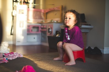 a little girl sitting on the potty for potty training tips