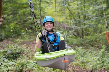 woman riding seated zipline at the Bronx Zoo