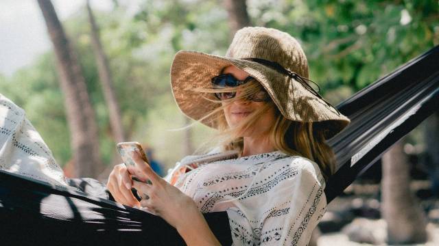 woman in hammock smiling wearing a sunhat and sunglasses - pregnant in summe