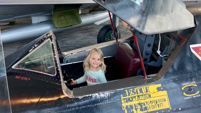 a little girl sits in a plane at the museum of flight in seattle