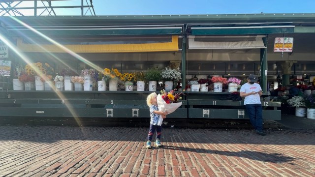 a little kid holds a fresh bouquet of flowers from pike place market in seattle