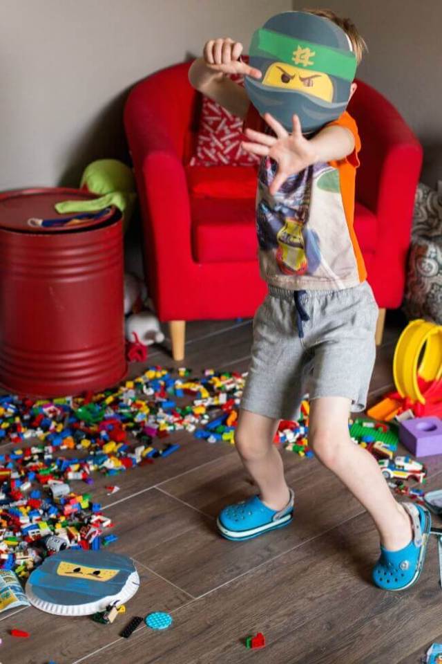 A little boy is dressed up for his LEGO themed birthday party with decorations from Spaceships and Laser Beams