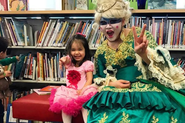 A girl with a drag queen at drag queen story time