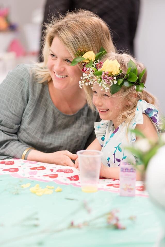 A girl with a flower wreath on her head and her mom host a crafting birthday party