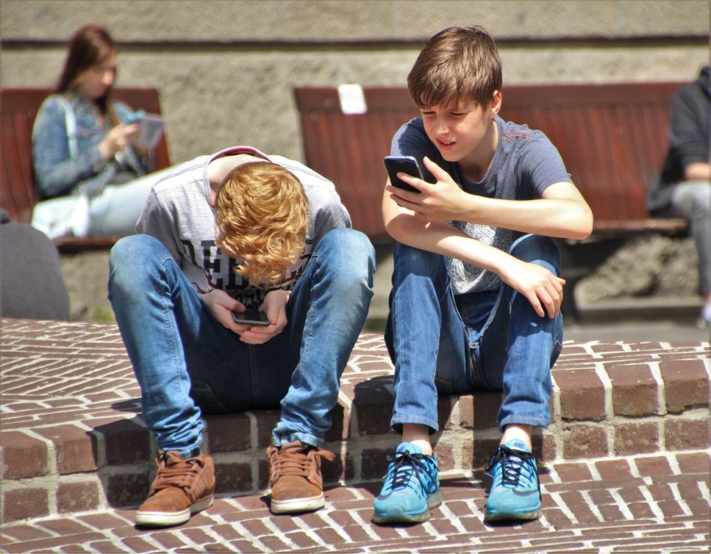 photo: pexels https://www.pexels.com/photo/2-boy-sitting-on-brown-floor-while-using-their-smartphone-near-woman-siiting-on-bench-using-smartphone-during-daytime-159395/