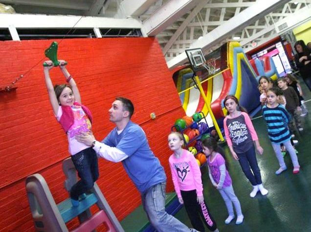kids playing on indoor zipline with adult spotting at Kids n Shape near NYC