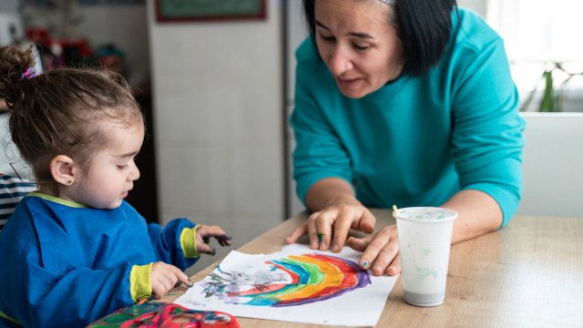 a picture of a mom and baby doing mother's day infant crafts