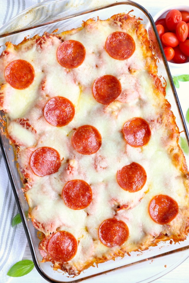 A pepperoni pizza casserole sits in a clear, rectangular dish