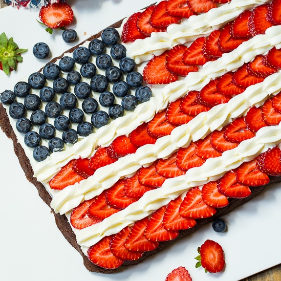 A big dish of brownies decorated with fruit and icing to look like the American flag for Memorial Day