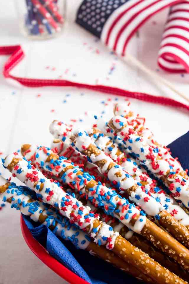 Pretzel sticks drizzled with white chocolate and patriotic sprinkles for Memorial Day
