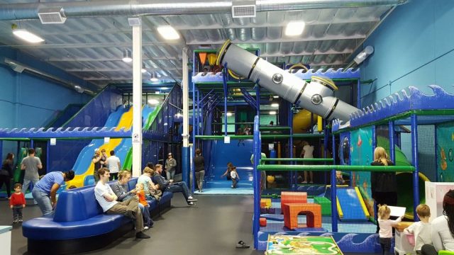 Children play at an indoor play structure