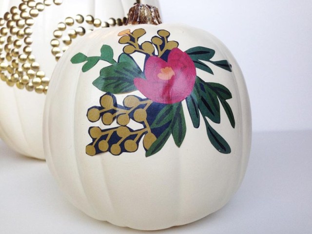 Two white pumpkins are decorate in colorful découpage