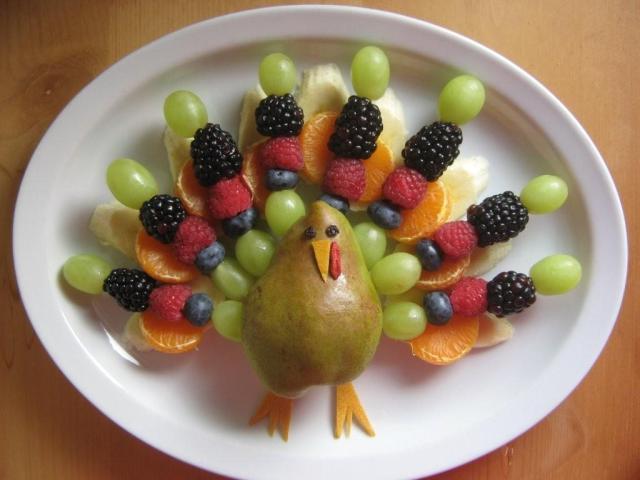 A platter of fruit shaped to look like a turkey sits on a white plate as a low-sugar alternative dessert to pie