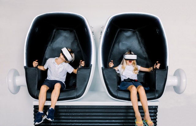 kids sit in a VR pod and look excited at an indoor playground Atlanta