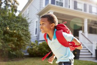 little boy going to school with a backpack