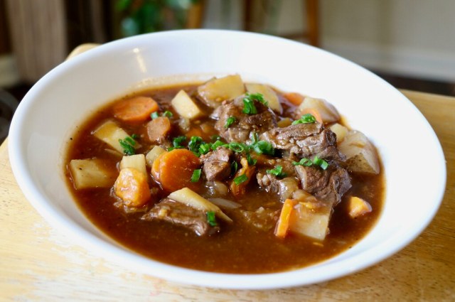 A white bowl of beef stew that was made from a Crock Pot