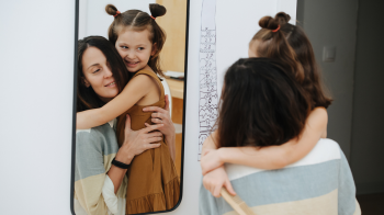 mom hugging daughter and saying positive things about herself
