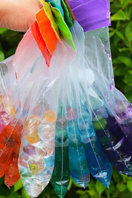 water beads fill sealed off plastic bags in rainbow colors, spring sensory play ideas