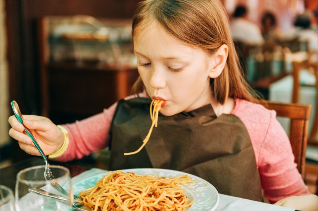girl enjoying spagetti at restaurants where kids eat free