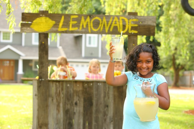 A girl hosts a lemonade stand as a fun family activity in summer