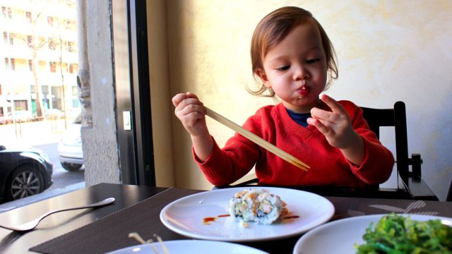 toddler enjoying sushi at restaurants where kids eat free