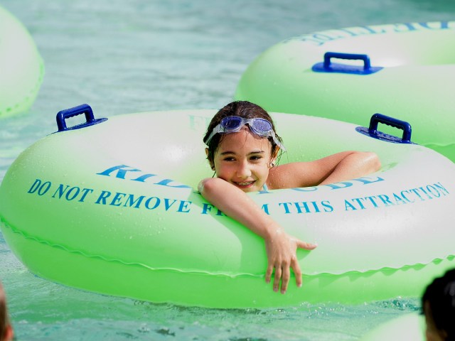 A kid floats on a tube along the lazy river at Wild Waves Theme and Water Park