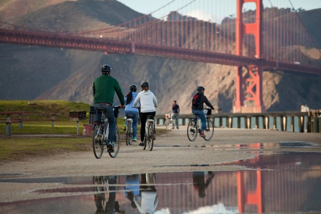 A group of bikers ride near the Golden Gate Bridge