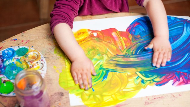 a child doing art, one of many pieces of kids artwork their parents will have to figure out what to do with