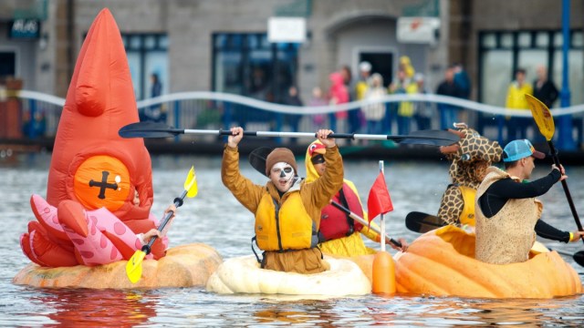 people dressed in Halloween costumes float in giant pumpkins on the river at this fall festival outside of Portland, Oregon
