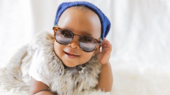 a baby wearing sunglasses and a blue cap is all about fun things to do with a baby in seattle