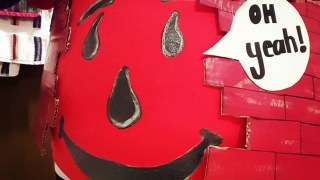 a close-up of a pregnant belly dressed as the Kool-Aid man for a roundup of halloween maternity costumes