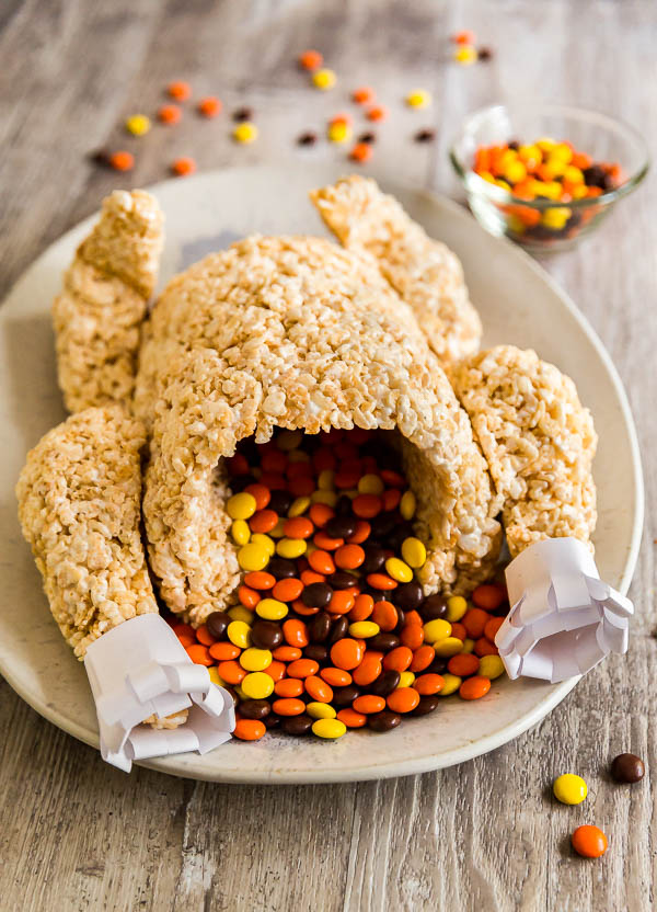 A rice crispy treat turkey with Reeses pieces spilling out of it to imitate stuffing