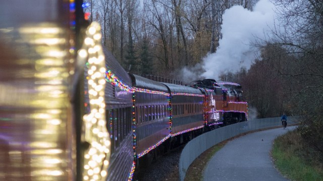 a lighted train with smoke coming out of its stack is one of the places to take pictures with Santa in Portland